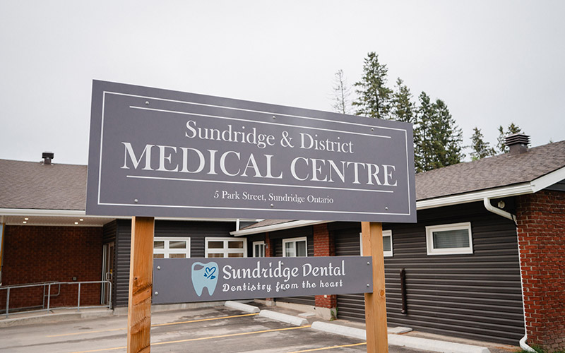 A view of the Sundridge and District Medical Centre building, with a grey sign in front.